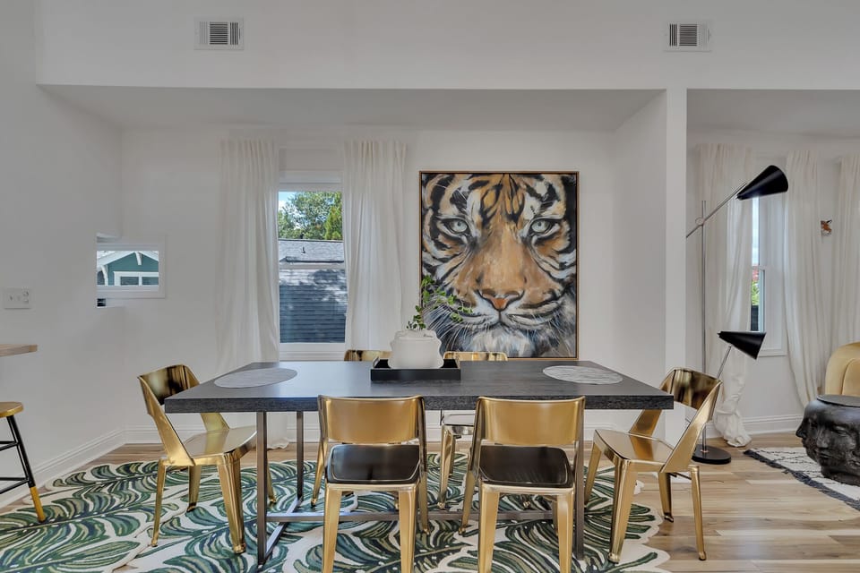 Dining table framed by large windows & striking tiger art for memorable meals