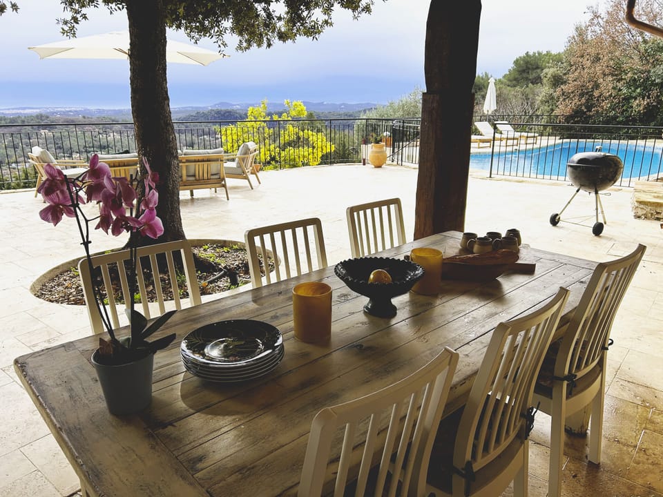 Outdoor dining area with view of the pool and across to Antibes 