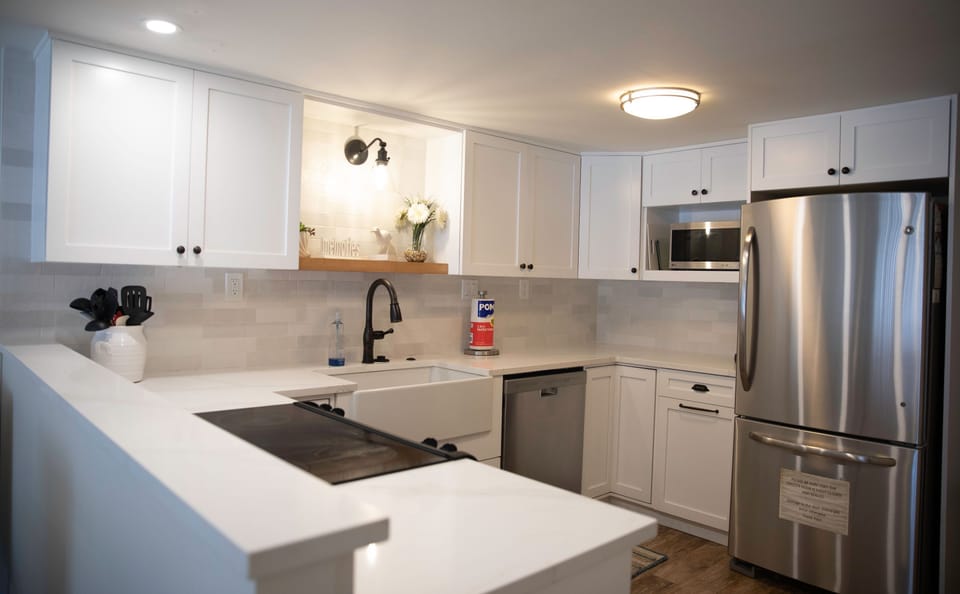 Enjoy the convenience of a fully equipped kitchen with stainless steel appliances and bright coastal décor, perfect for preparing delicious meals during your relaxing beach getaway.