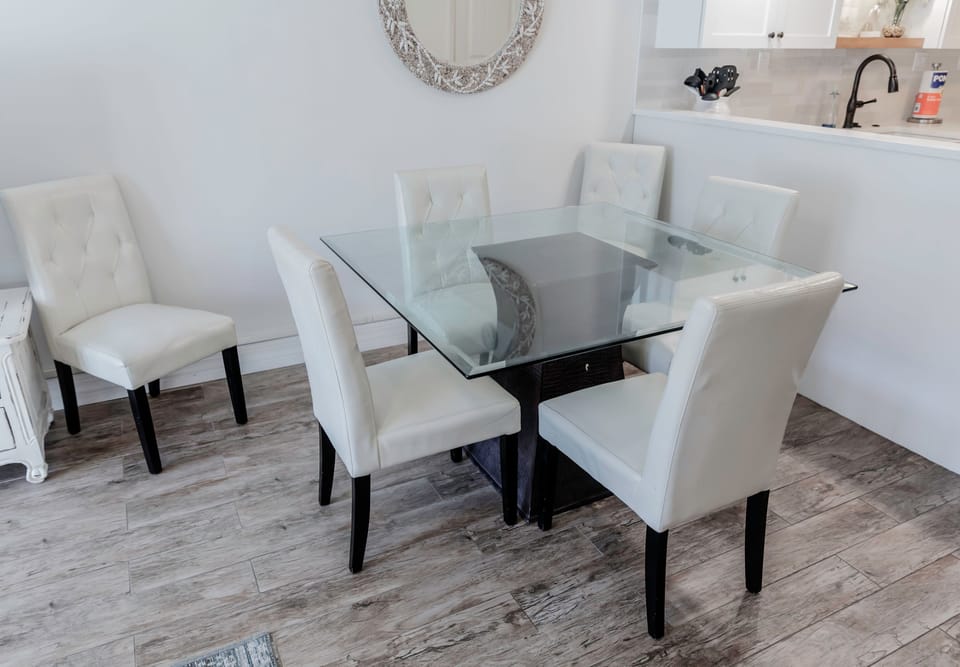 Gather for meals in this stylish dining space featuring a glass-top table and plush seating—perfect for enjoying family dinners during your relaxing beach vacation.