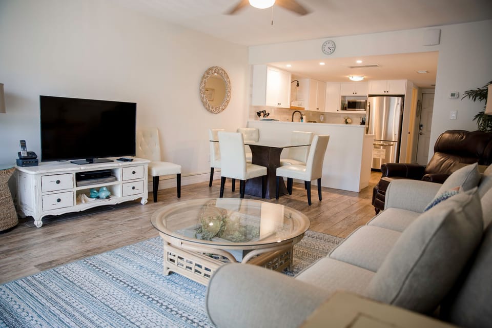 Unwind after your beach adventures in this inviting condo featuring a cozy living area, modern kitchen, and dining space—perfect for making memories on your coastal getaway.