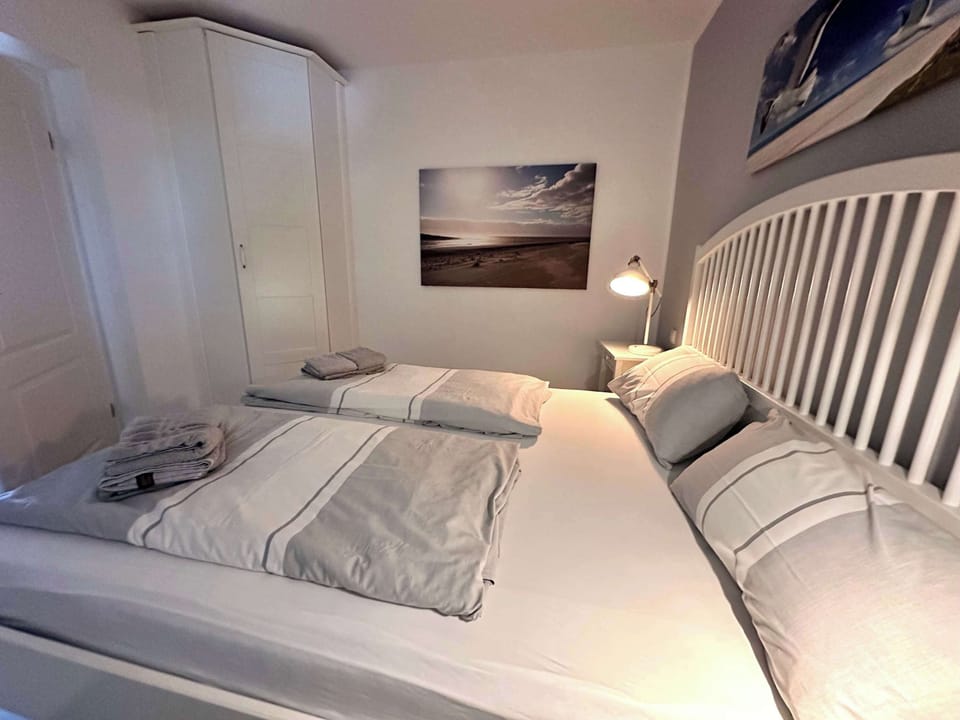 Schlafzimmer 2 mit 160er Bett, Fenster mit Plissé und Kleiderschrank.
