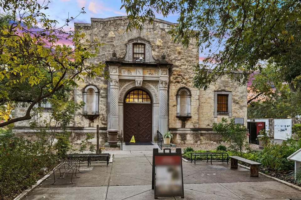 Discover a historic courtyard entrance framed by tranquil greenery.