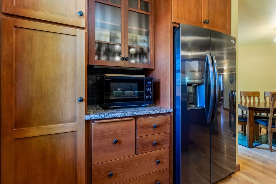 Kitchen with microwave and refrigerator with ice maker and water