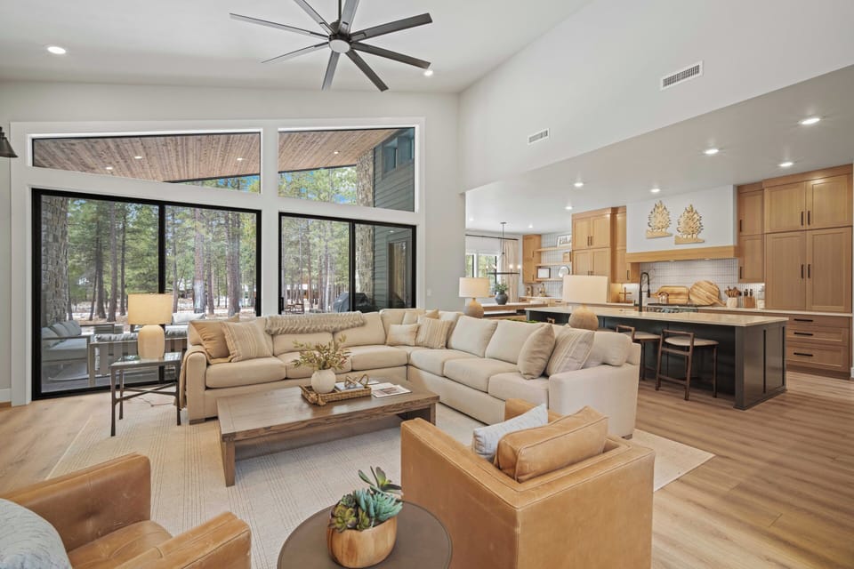 Unwind in your spacious open-plan living area where natural light floods through floor-to-ceiling windows overlooking peaceful forest views.
