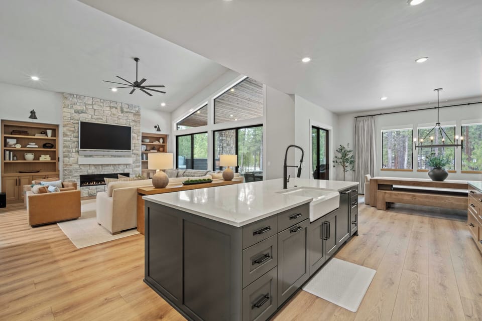 Your spacious open-plan haven combines kitchen, living, and dining areas with warm wood floors, cozy fireplace, and peaceful garden views.