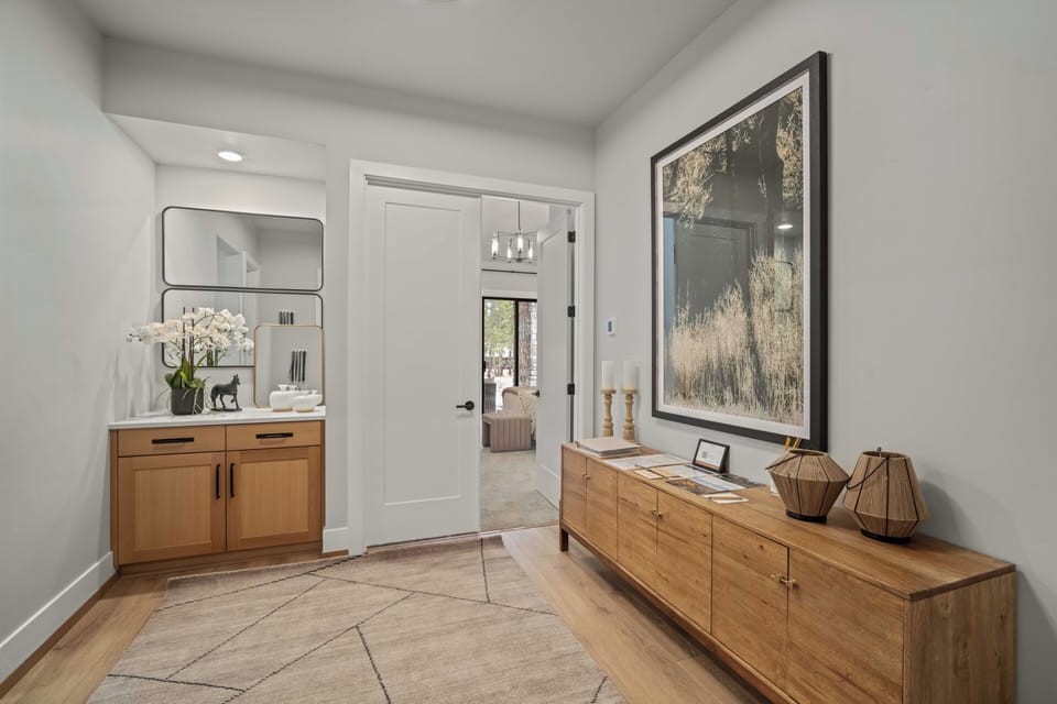 Step into your stylish entryway with warm wood furnishings, elegant artwork, and thoughtful design touches that welcome you home.