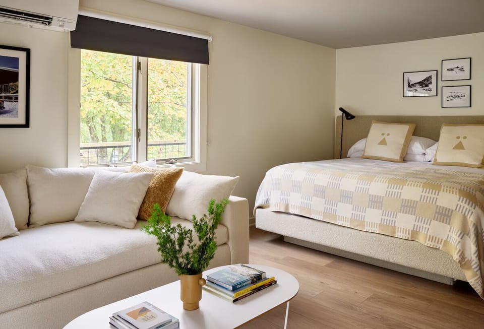 Unwind in a sunlit suite with plush bed and sofa