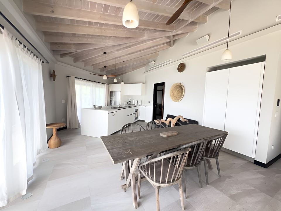 Gather for relaxed meals in a sunlit, designer kitchen.