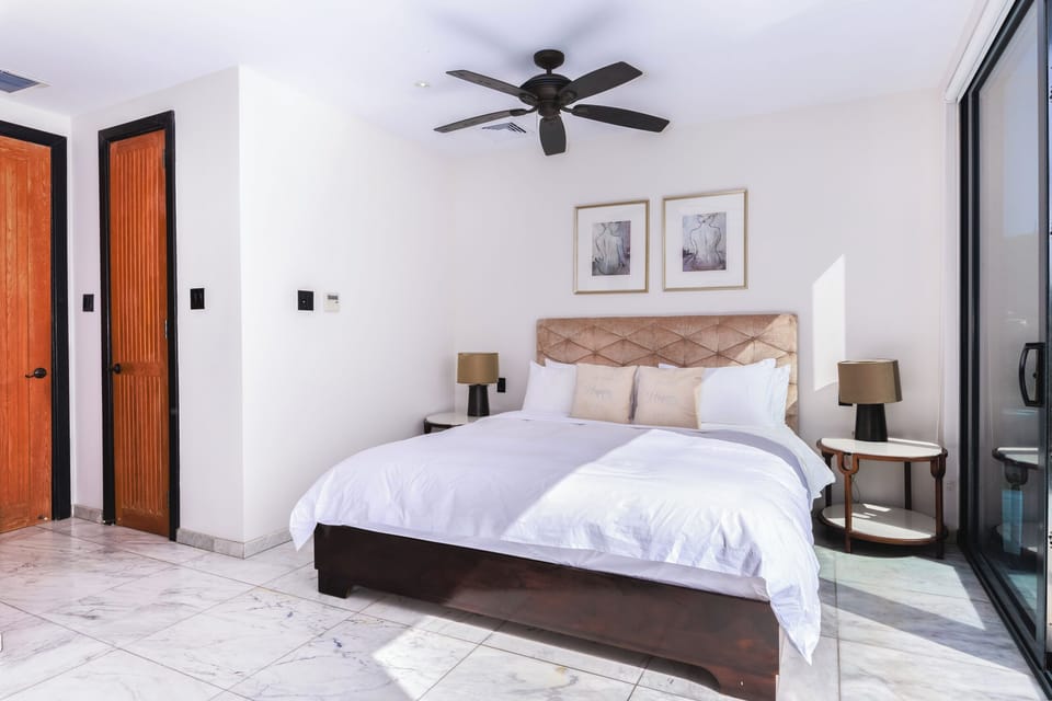 Drift off in crisp linens beneath a cooling ceiling fan.