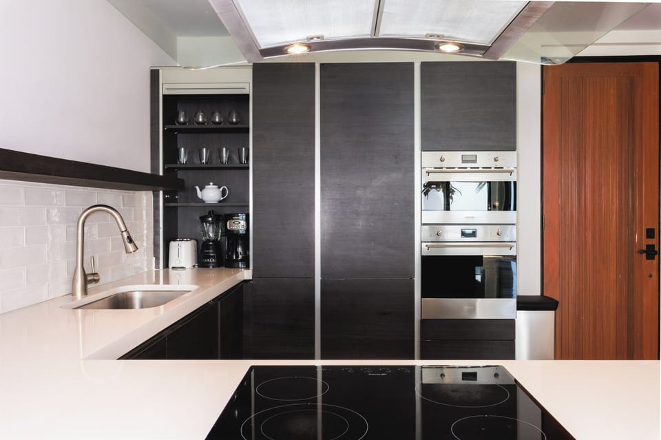 Brew morning coffee with sleek built-ins and glassware ready.