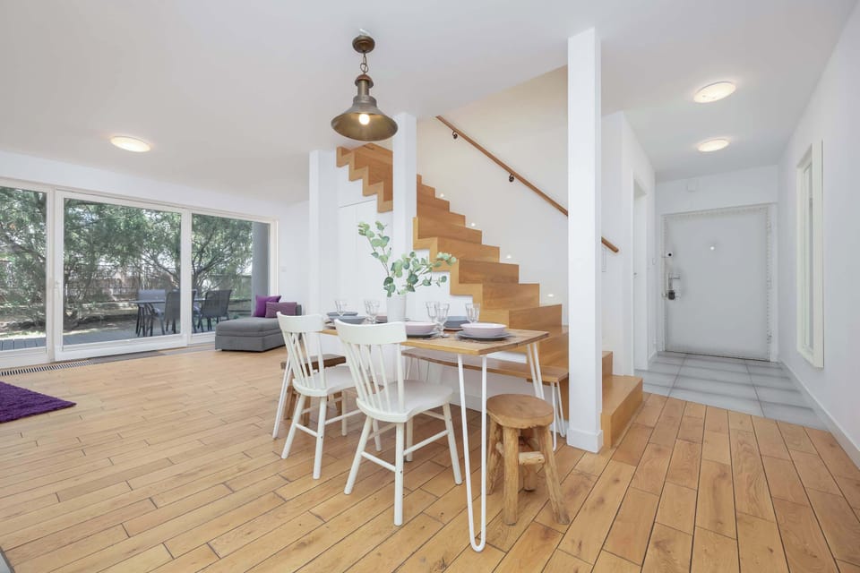  A stylish dining corner with a wooden table, designer lighting, and tasteful decor.