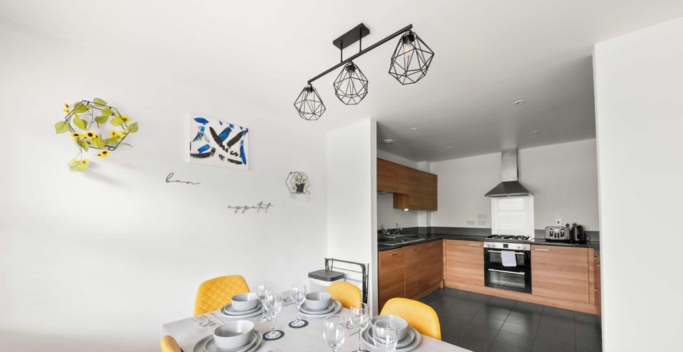 This modern dining area is such a bright and cheerful spot to enjoy a meal! It features a sleek grey dining table set for six, paired with beautiful mustard yellow quilted chairs that add a cozy and vibrant touch to the room.