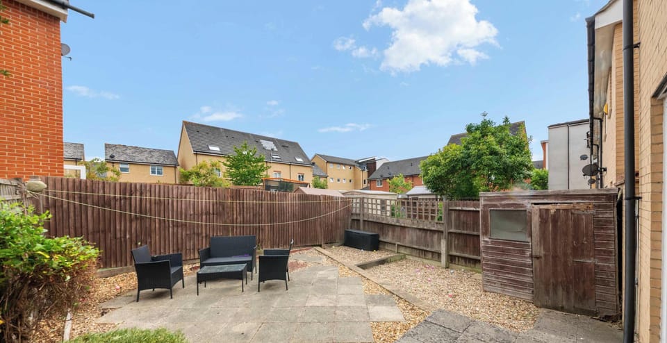 This charming exterior is a peaceful outdoor retreat, perfect for soaking up the sunshine in a quiet setting. The space is neatly designed with a mix of stone paving and gravel, making it a very simple design.