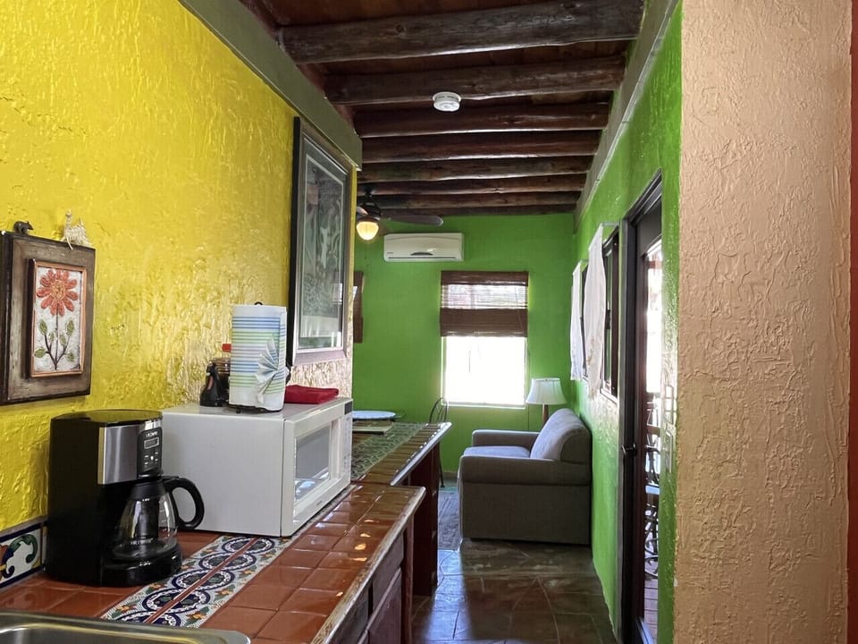 Prepare food in the galley kitchen while chatting with others on the sofa in the living room