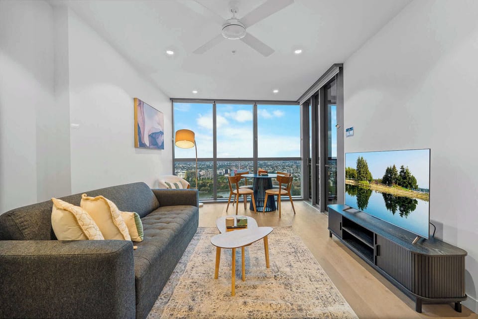 Stylish living space with TV and cosy seating, designed for comfort during your stay.