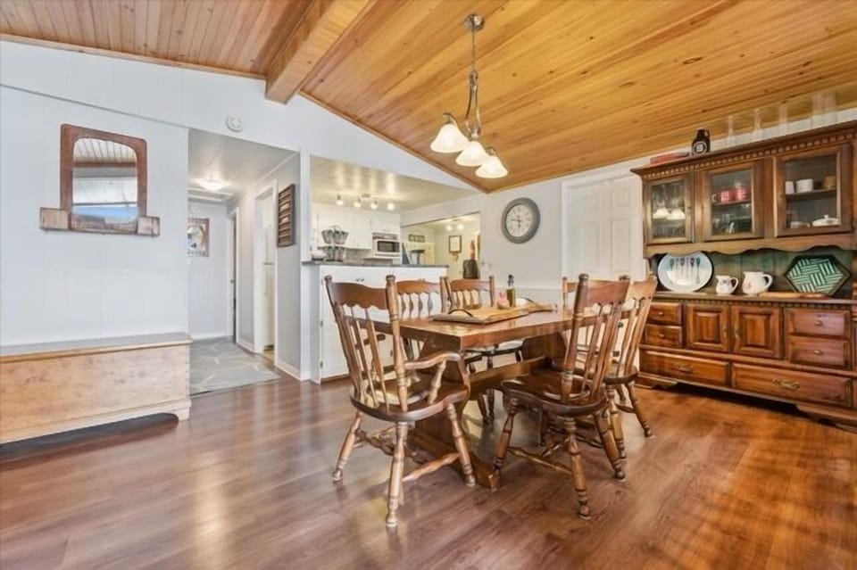 Gather around the solid wood dining table for shared meals and games in a warm, welcoming space that opens to the living area.