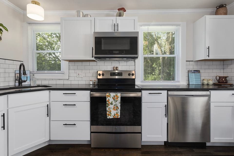 Full kitchen with stainless steel refrigerator, electric stove, dishwasher and microwave/convection oven. New granite countertops and an island for additional space make this kitchen fully functional. Cleaning supplies under kitchen cabinet. 