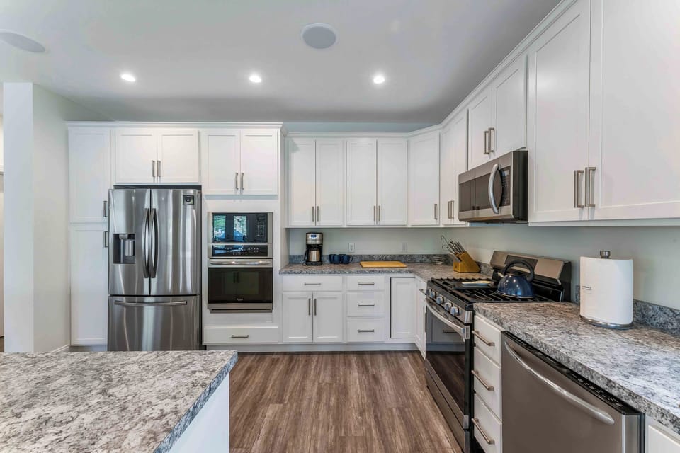 Cook with ease in a fully equipped kitchen featuring stainless steel appliances and double ovens.