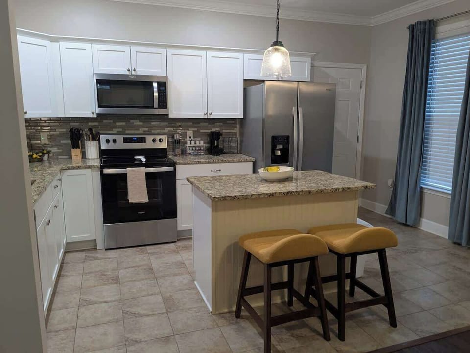 The kitchen as seen from the master bedroom hallway entrance. The back door is shown to the right of the refrigerator. 