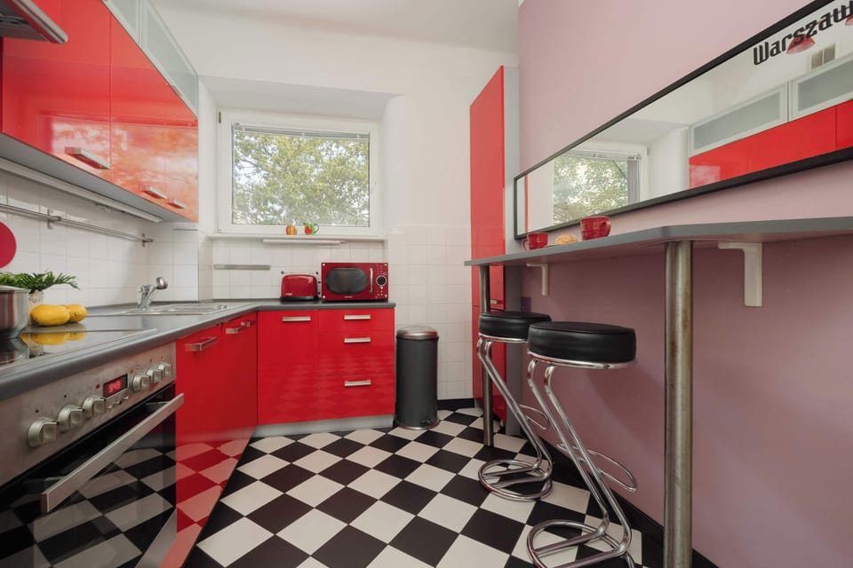 A sleek red and gray kitchen setup with bar stools and upper cabinets providing extra storage.