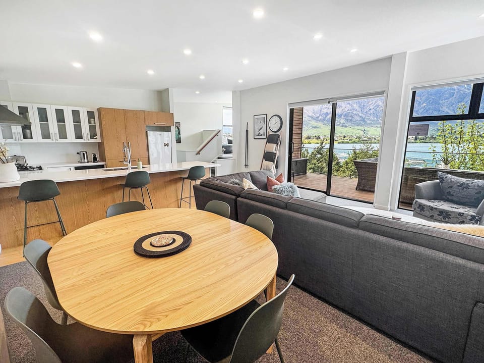 Bright open-plan dining and lounge space with seamless flow to the outdoor deck and lake views.
