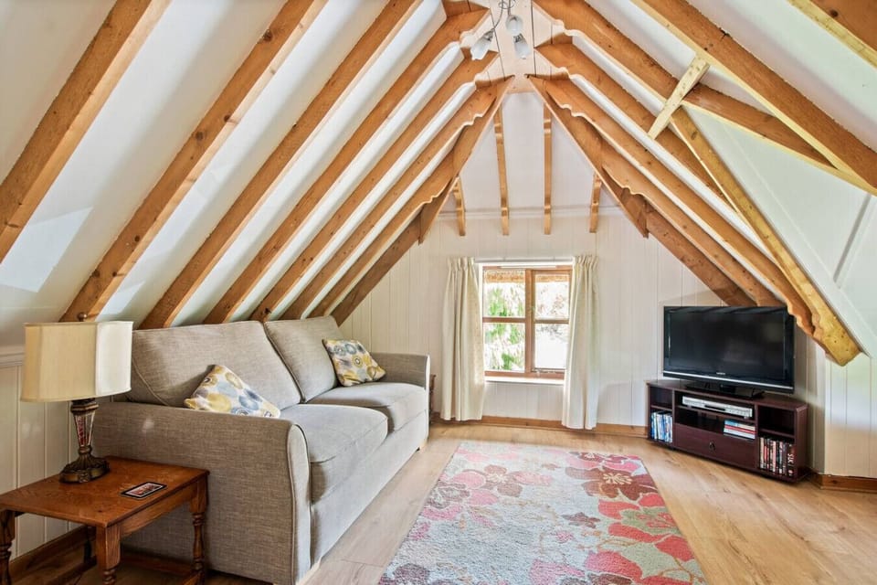 Cosy upstairs lounge with beams and TV