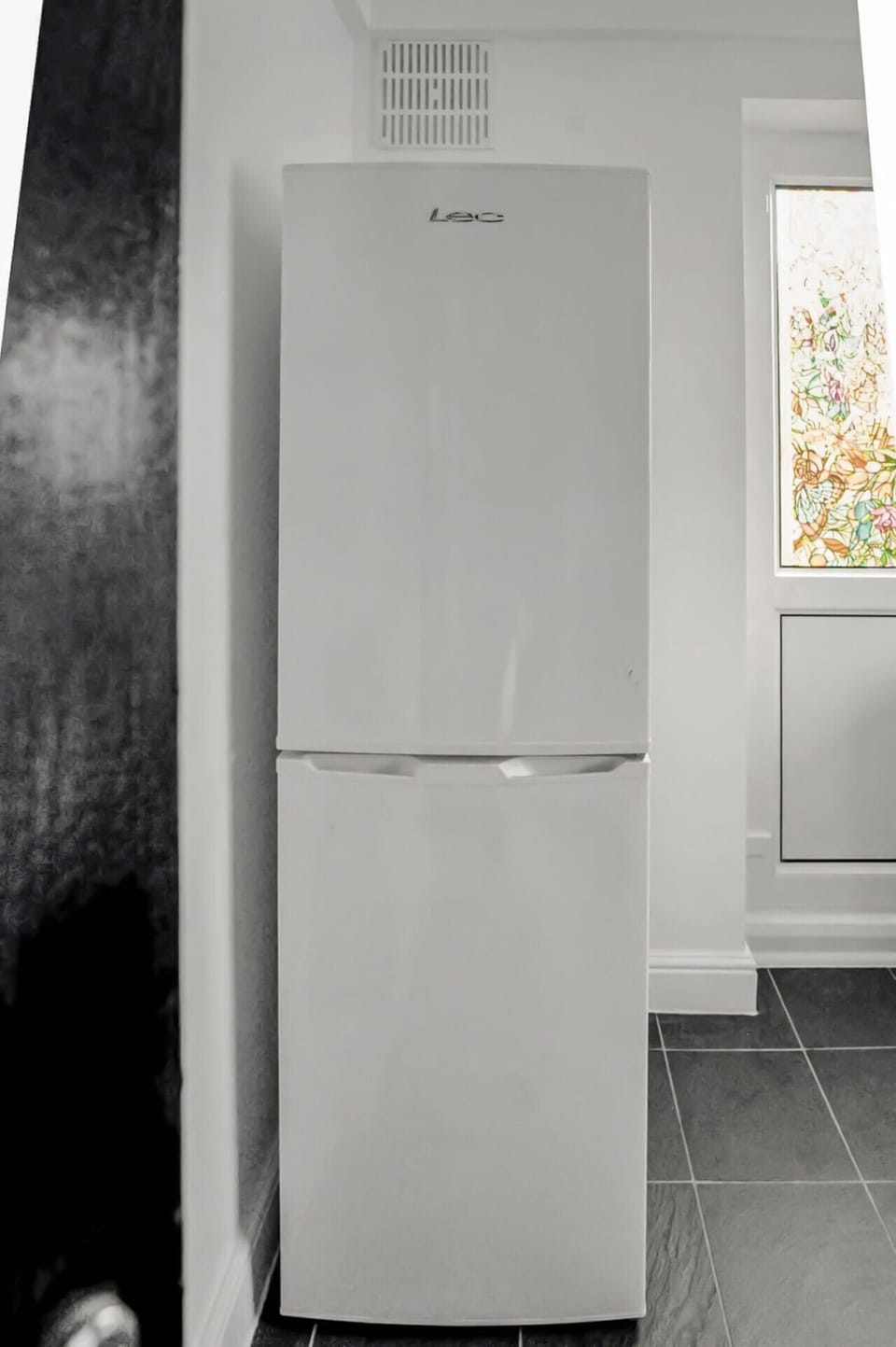 Tall fridge-freezer in kitchen corner