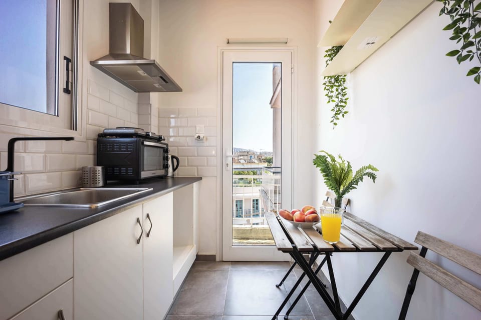 Sunlit kitchenette leading to balcony, creating a bright and practical cooking space.