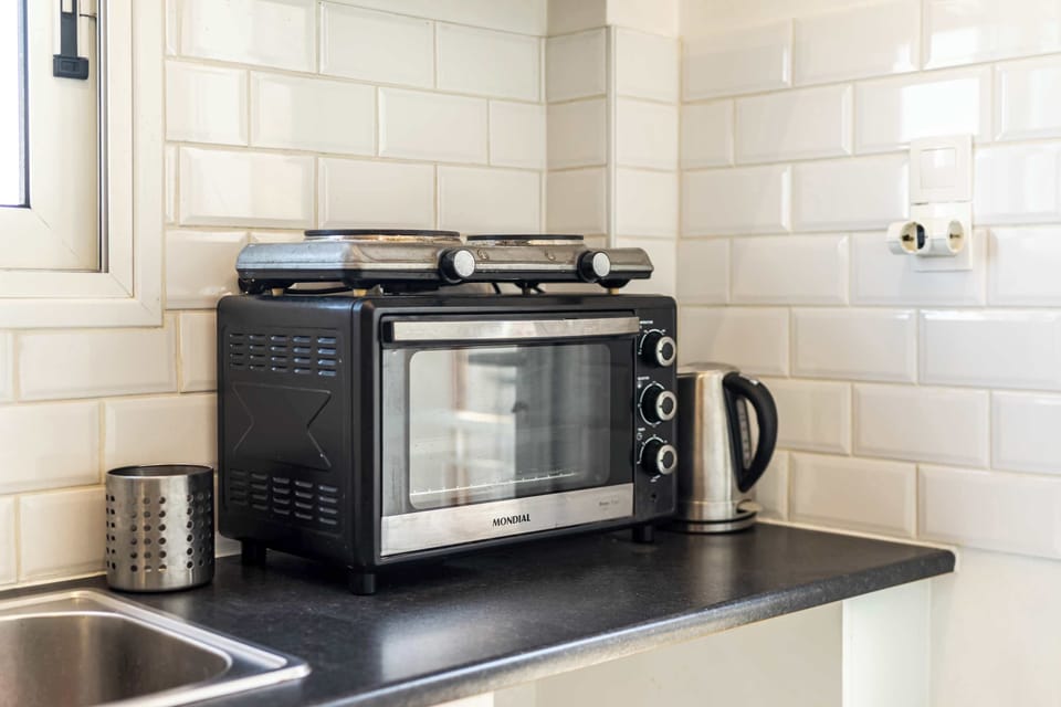 Well-equipped countertop with oven and kettle for quick breakfasts or simple dinners indoors.