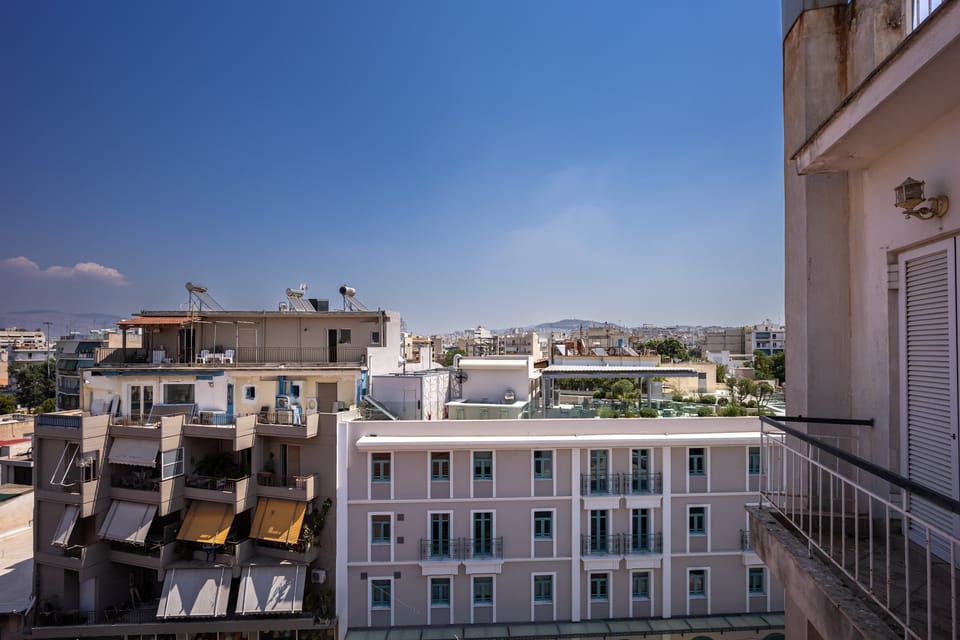 Wide urban panorama stretching to distant hills, offering a peaceful high-above-the-city perspective.