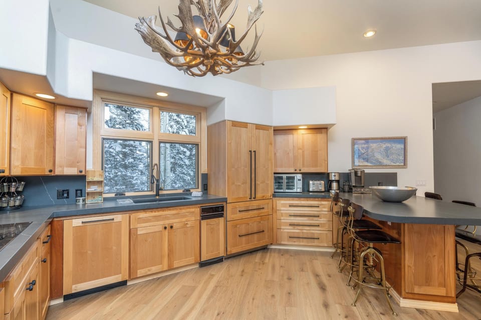 Your fully equipped gourmet kitchen features warm wood cabinetry, sleek countertops, and modern appliances - perfect for preparing memorable meals during your stay.