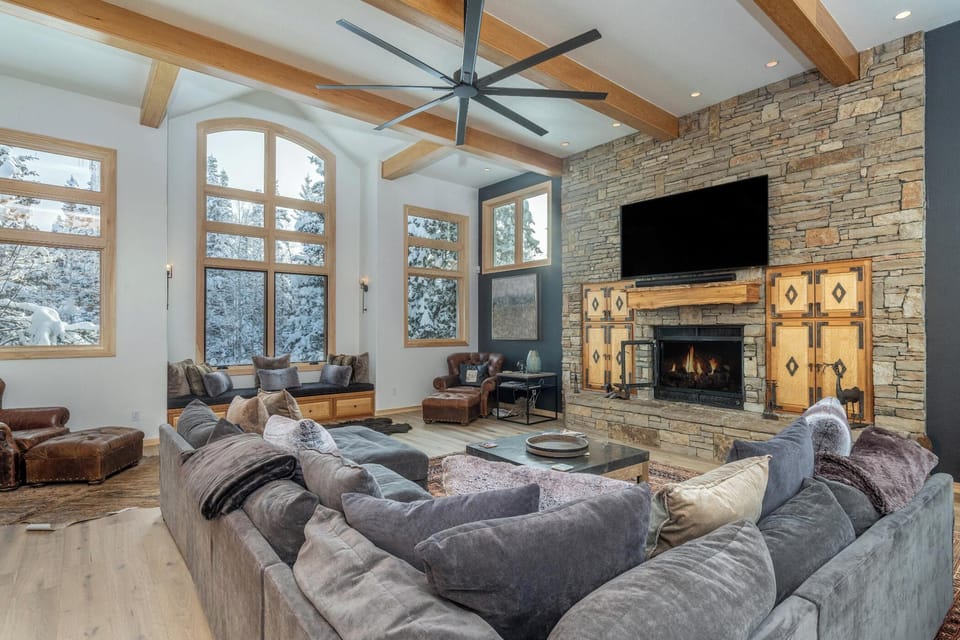 Sink into plush seating by your cozy fireplace while enjoying mountain views through expansive windows in this beautifully appointed living space.