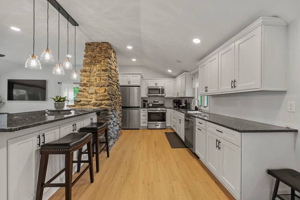 Fully equipped kitchen with stainless steel appliances, including refrigerator, oven, microwave, and dishwasher.