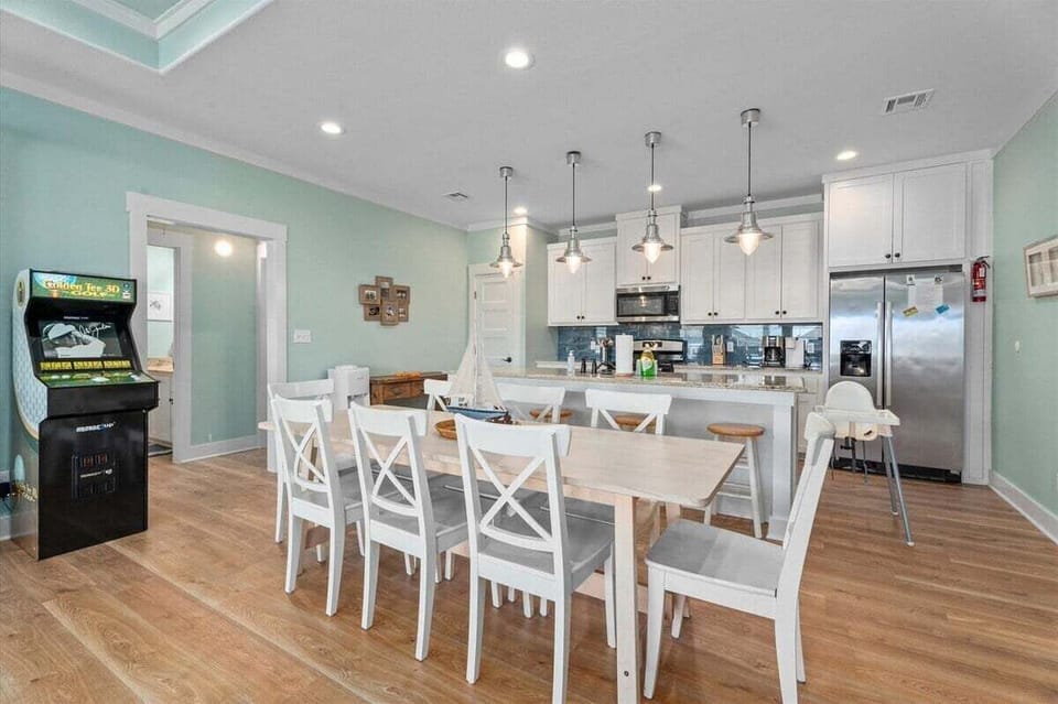 Large dining area with seating for multiple guests, adjacent to a fully equipped kitchen and open-concept gathering space.