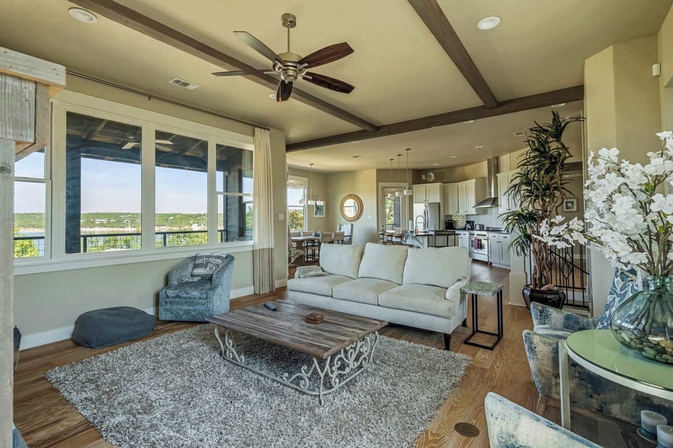 This bright, open-concept living room offers a welcoming space to gather, complete with a view of Lake Travis.