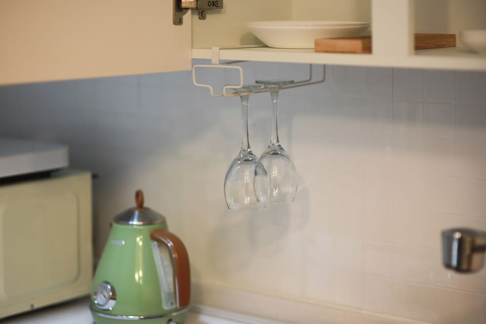 wine glasses, an electric pot, a microwave oven
