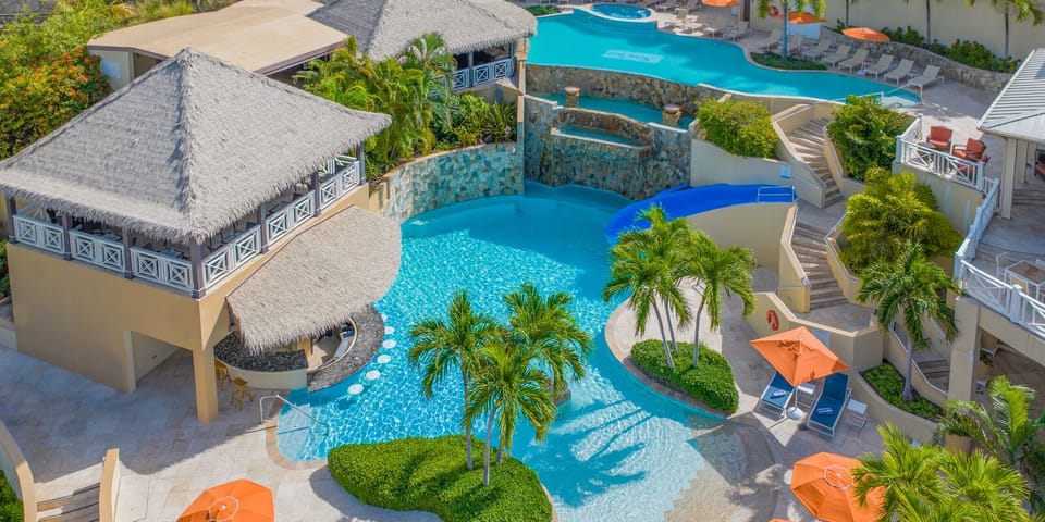 Dive into a cascading pool oasis framed by palms.