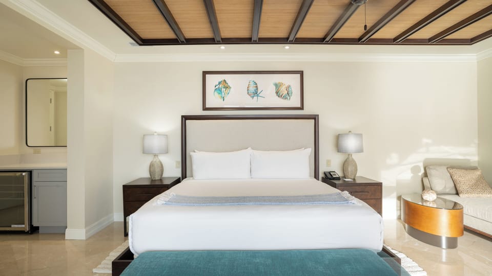 Recharge in a serene king bed beneath warm wood ceilings.