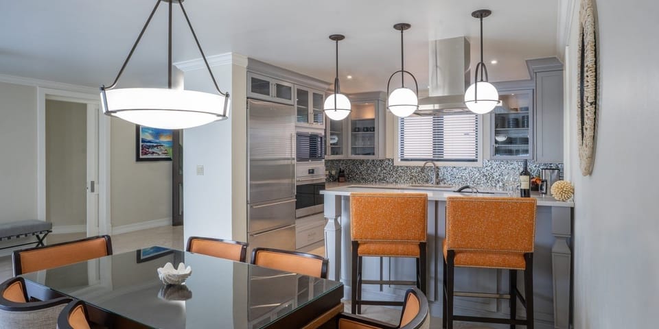 Host relaxed dinners under statement lighting beside the open kitchen.