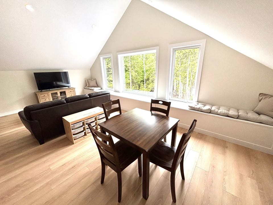 A versatile family zone – this spacious upper-level living and dining area includes board games, extra TV space, and a cozy place for group meals or rainy-day fun.