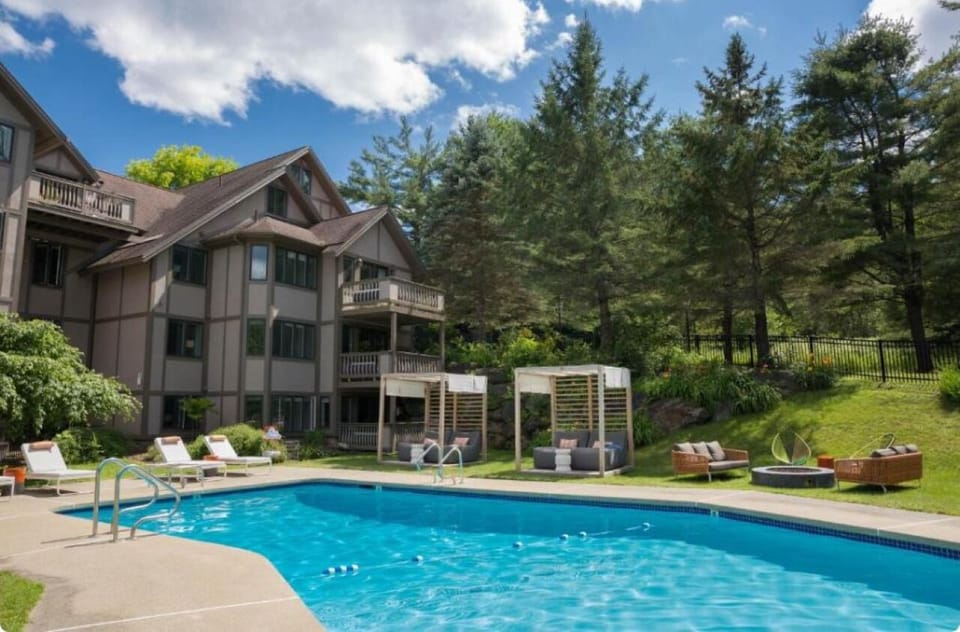Dive into sunlit serenity with cabanas and forest views.