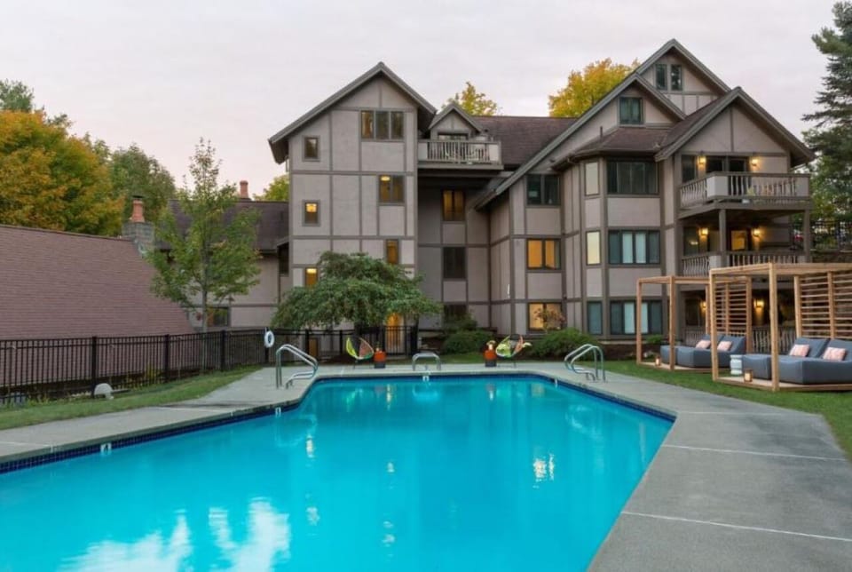 Unwind at dusk beside the glowing pool and chalet backdrop.