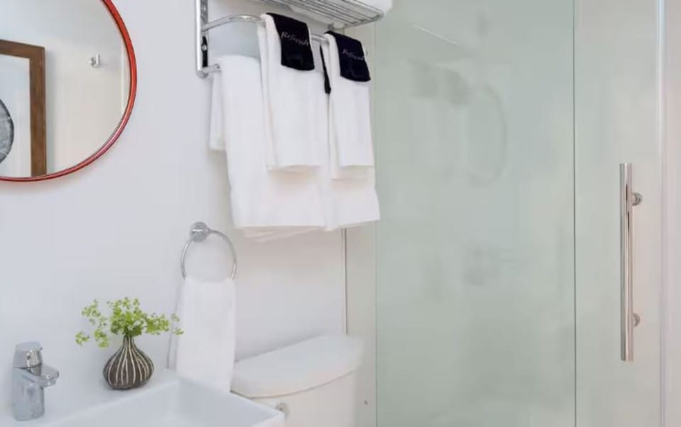 Refresh in a spotless, glass-shower bathroom with fluffy towels.
