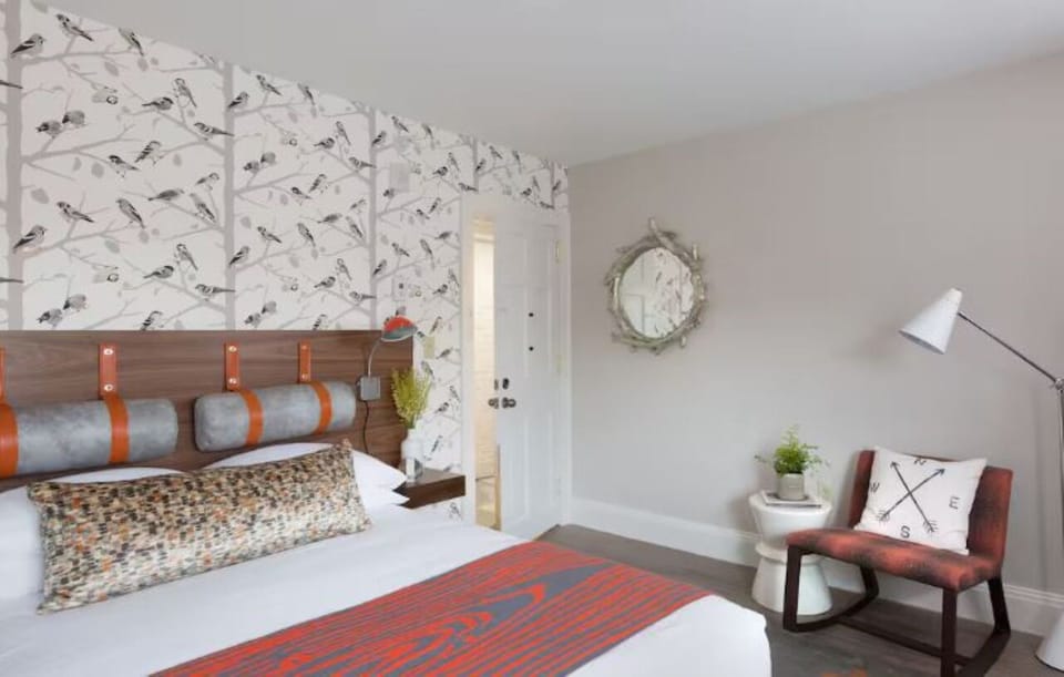 Unwind into crisp linens and a designer headboard backdrop.