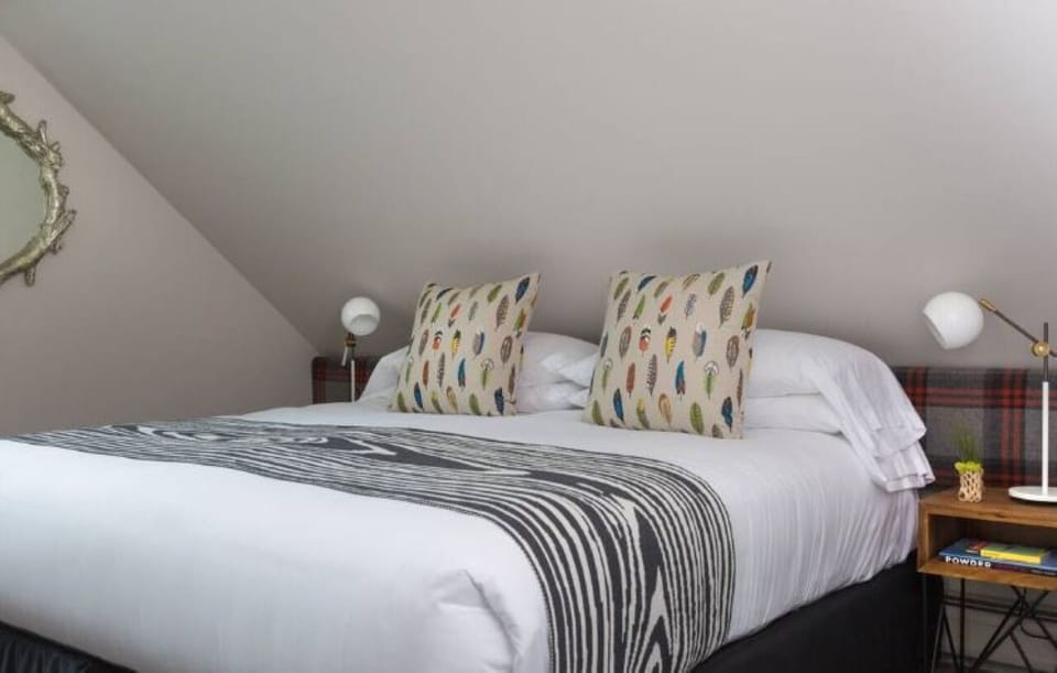 Unwind into crisp linens beneath cozy, sloped-ceiling charm.