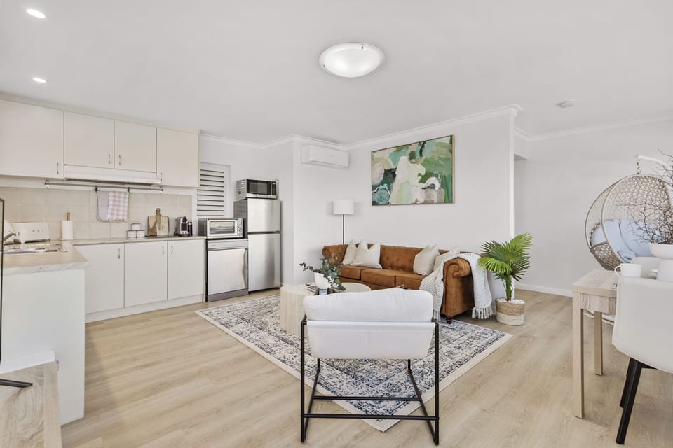 Unwind in this bright and airy open-plan space with a plush sofa and a modern armchair.