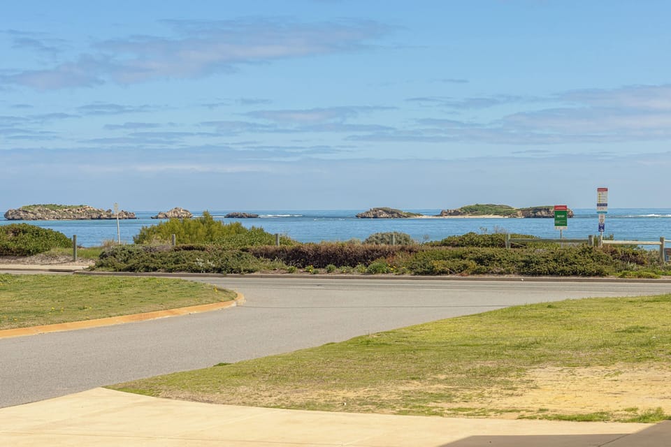 Glimpse the natural beauty of tranquil blue waters, rocky islands, and lush greenery under a partly cloudy sky.