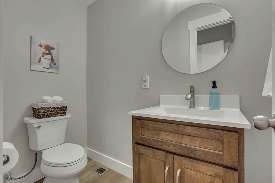 This half bathroom is conveniently located just off the living room, at the top of the steps leading to the basement.