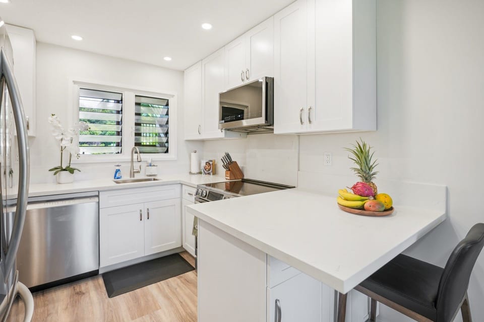 Bright, modern kitchen with island seating and tropical flair.